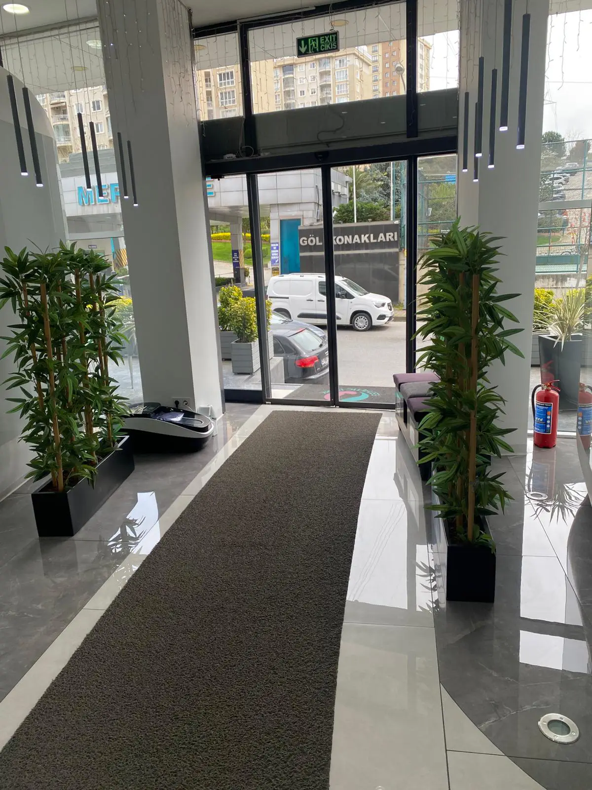 Modern, bright entrance and reception area at EsteQuality Dental Clinic in Istanbul, with glass doors and polished floors.