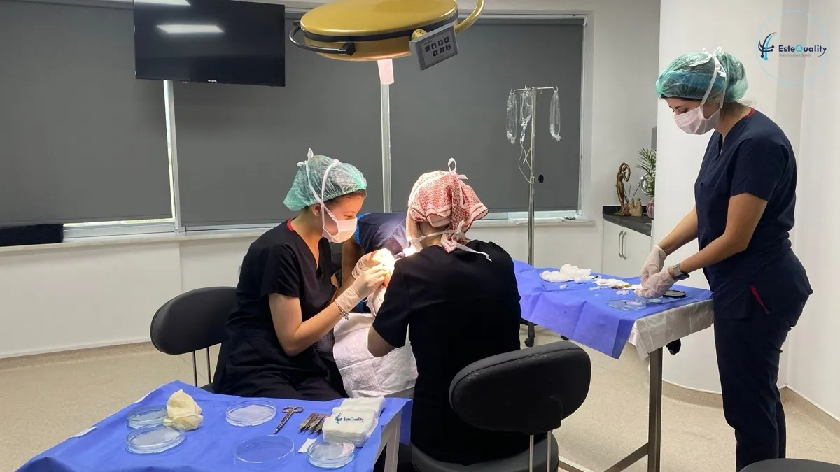 Medicul care efectuează procedura extrage grefe în timpul unui transplant de păr la EsteQuality, în timp ce un asistent colectează grefele
